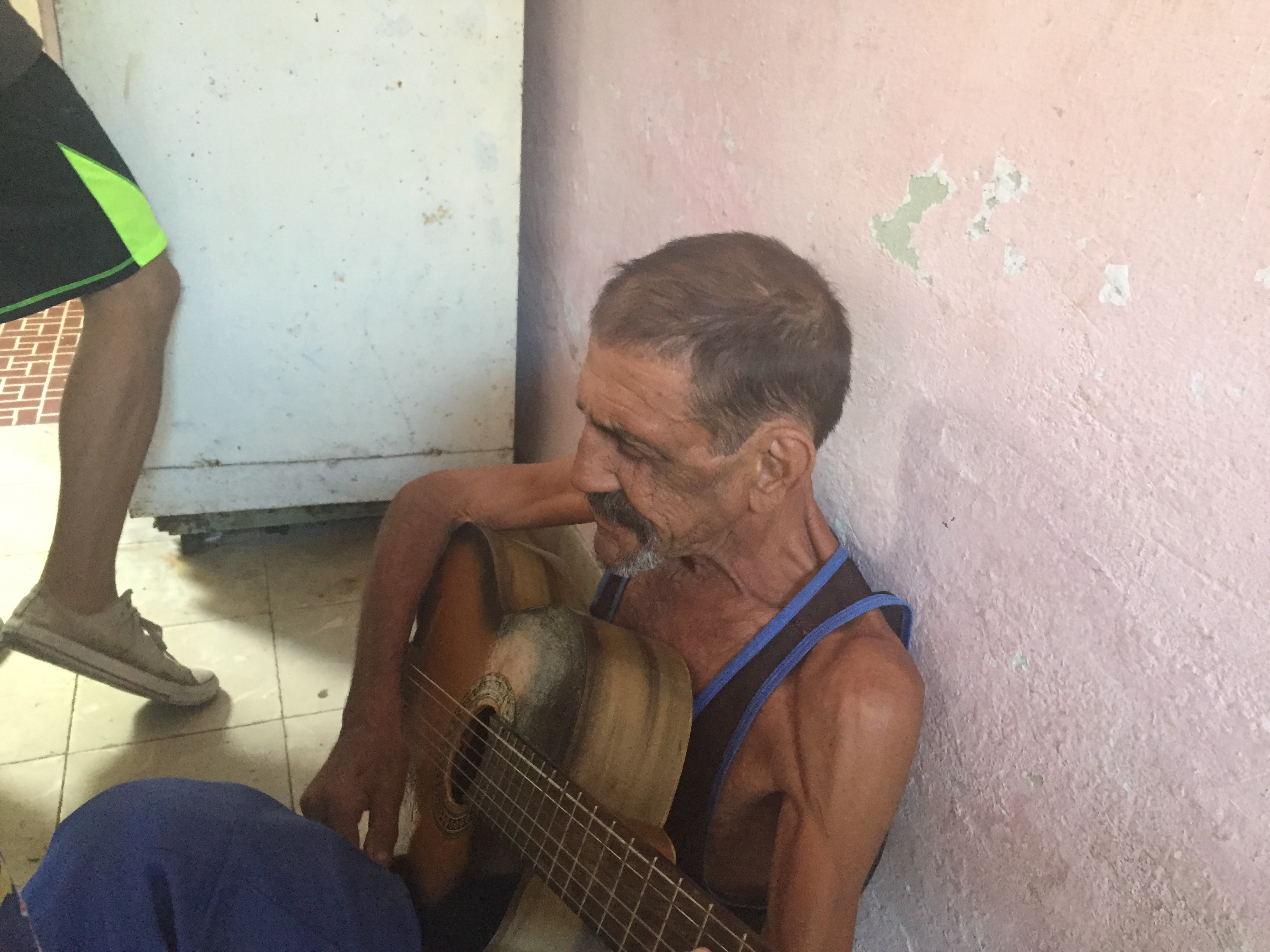 Papi con una boina del Che Guevara, guitarra al hombro, cantando entre la familia.